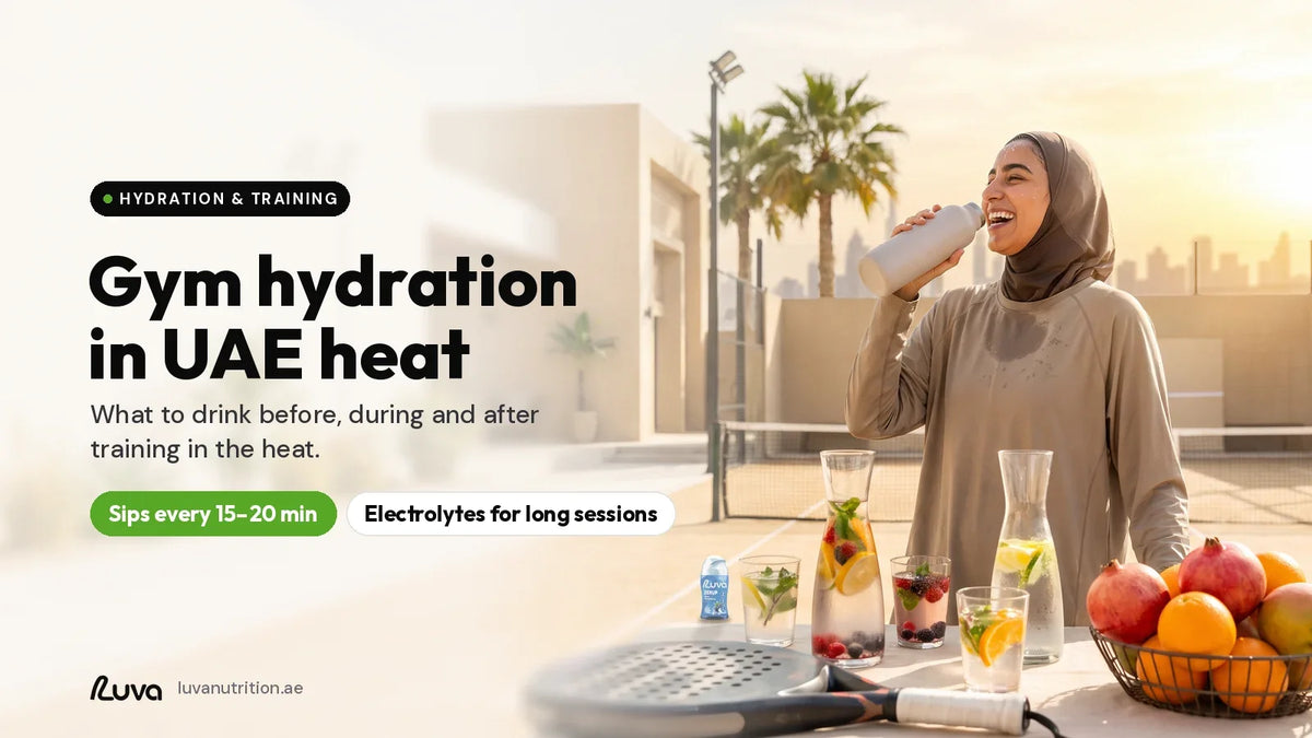 Gym hydration in UAE heat: woman in modest sportswear drinking water on a padel court at sunset in Dubai, with a LUVA ZERUP Blue Raspberry sugar-free syrup bottle