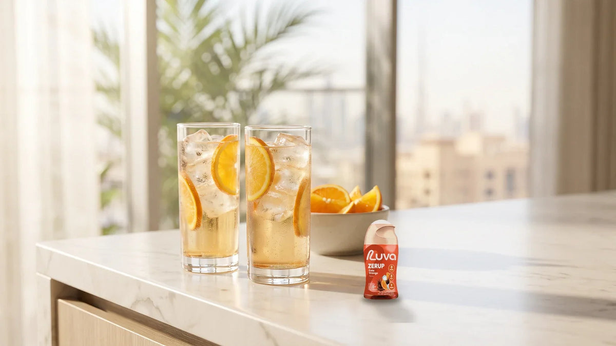 ZERUP by LUVA Cola Orange bottle next to two glasses of iced cola-orange drink in a bright Dubai kitchen